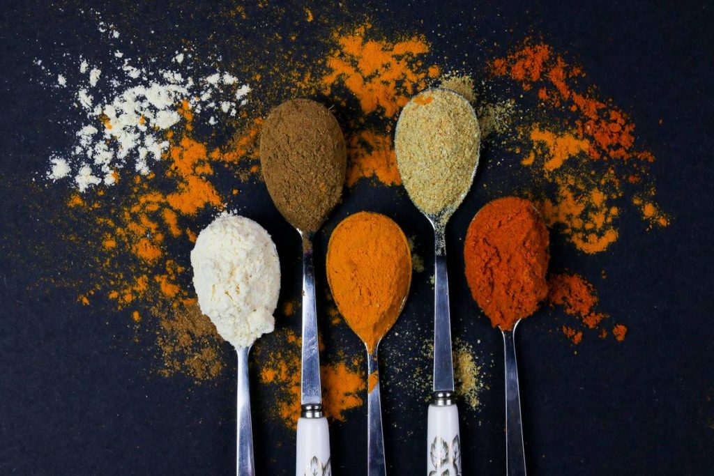 Colorful various herbs and spices for cooking on dark background